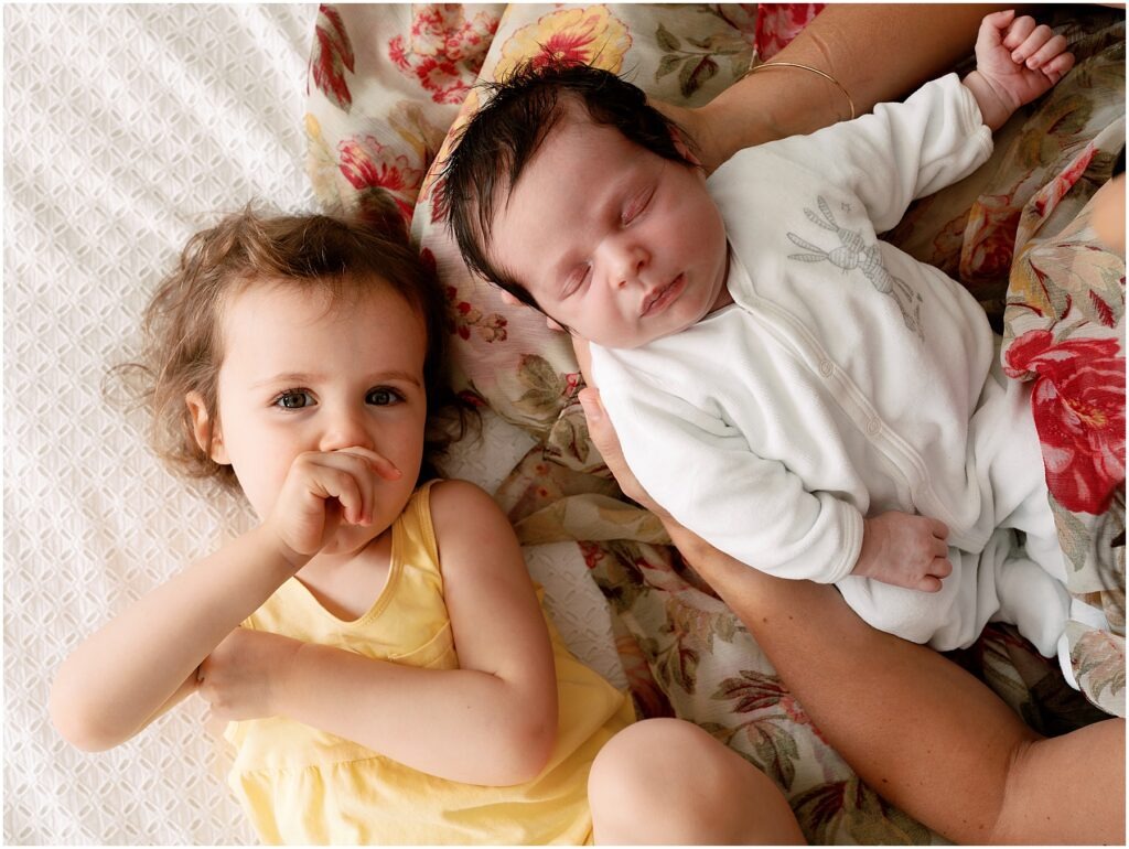 Newborn and Sisters lying down together